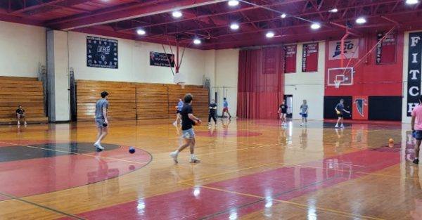 Student athletes from the red team (left) competing against the blue team (right) in the large gym at Fitch High School.